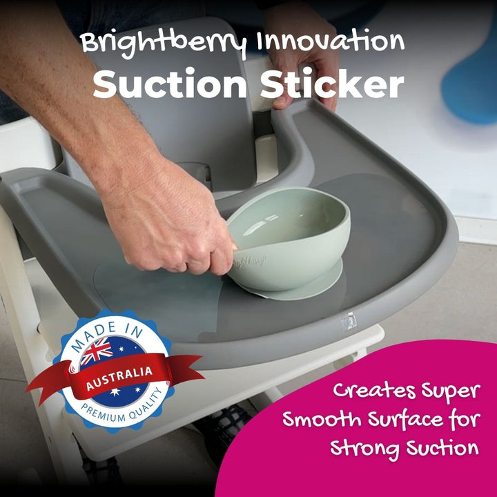 A person pulling a bowl from a high chair tray. The high chair has a smooth surface and a long-lasting suction sticker so the bowl doesn't budge.