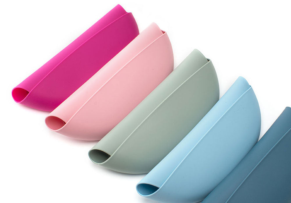 roll and go silicone bibs in shades of pink, blue and green